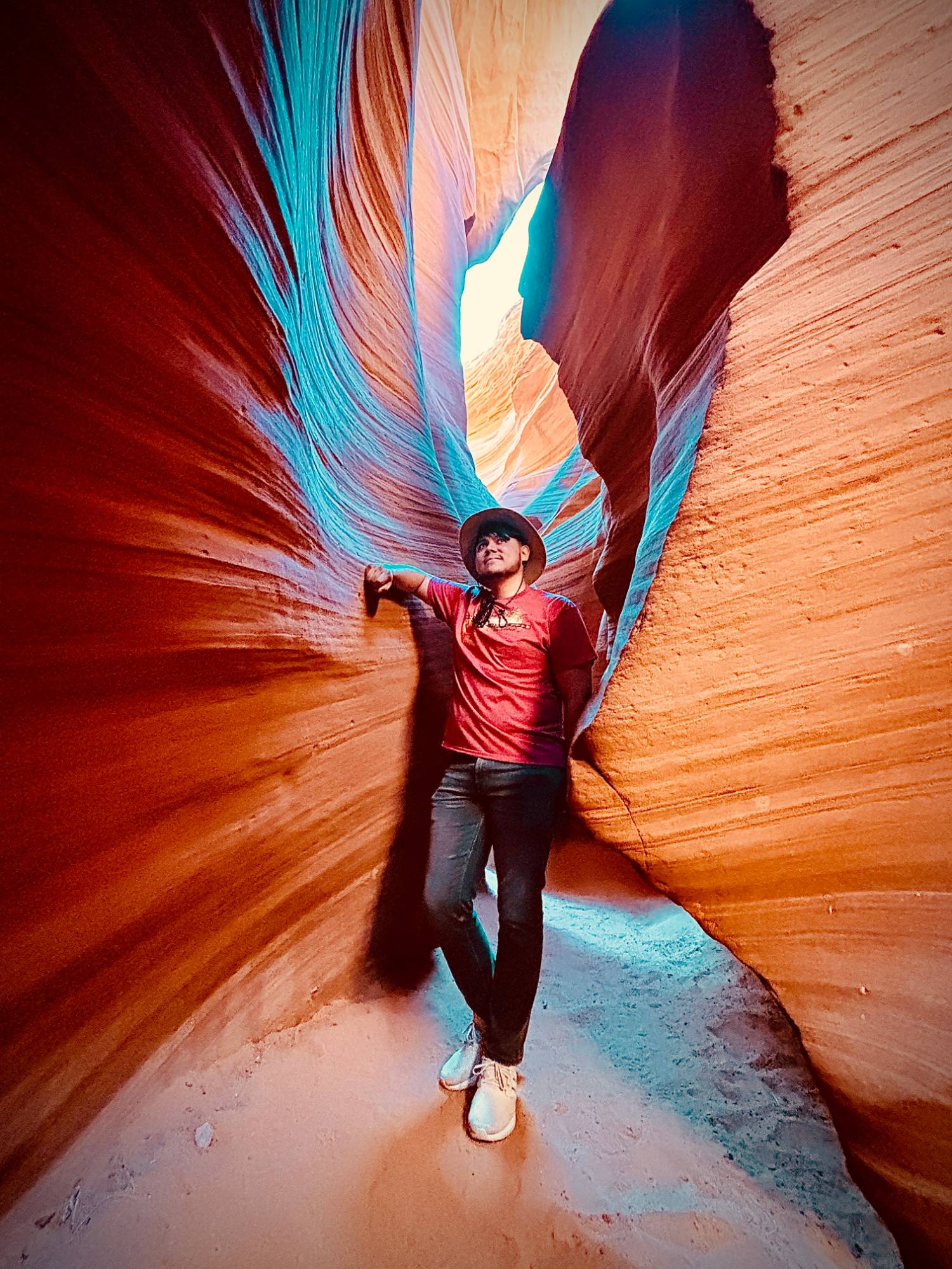 Steven exploring a slot canyon in a wide-brimmed hat